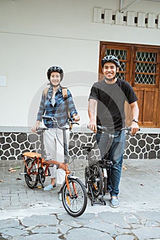 Asian young couples prepare folding bikes and wear helmets before going out