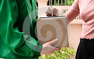 Asian young customer girl sign receipt on smartphone with stylus in service application and received postal box while delivery man