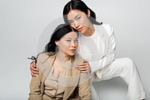 asian young daughter hugging brunette mother