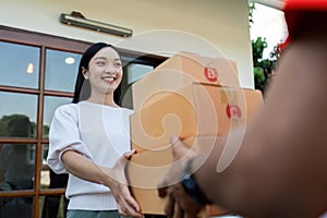 Asian young delivery man delivering package to female customer at home