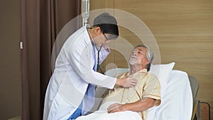 Asian young doctor using X-ray film explain the symptoms to the patient after treatment . surgeon Talking With old man patient on