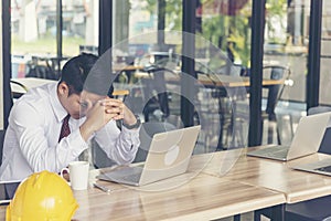 Asian young engineer man stress and failure in architecture project sitting at office on construction site. Upset despair civil