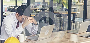 Asian young engineer man stress and failure in architecture project sitting at office on construction site. Upset despair civil