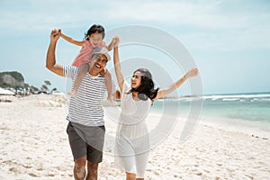 Asian young father carrying his daughter on his back