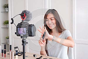 Asian young female blogger recording vlog video with makeup cosmetic at home online influencer on social media