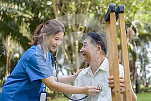 Asian Young Female Doctor Check Older Adult Health Condition and Provide Encouragement During Treatment. Rehabilitation or
