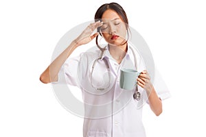 Asian young female doctor got headache with a cup of coffee