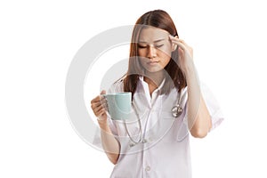 Asian young female doctor got headache with a cup of coffee.