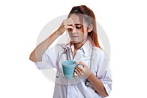 Asian young female doctor got headache with a cup of coffee.