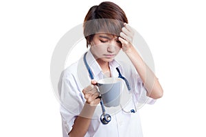 Asian young female doctor got headache with a cup of coffee.