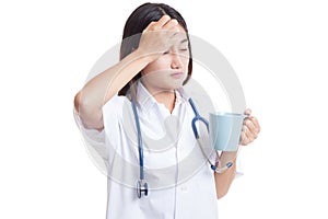 Asian young female doctor got headache with a cup of coffee.