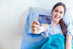 Asian young female patients show a demo credit card in hand. To pay medical expenses With smiles and bright facial expressions in