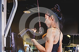 Asian young fitness woman execute exercise with exercise-machine in gym