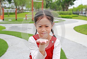 Asian young girl child show expression hand holding something and looking without theme while in the garden