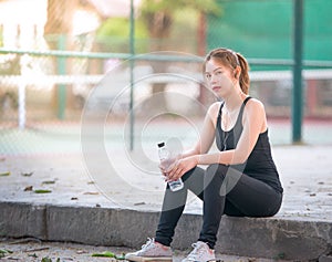 Asian young girl Fitness woman To drink water after jogging