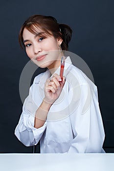 Asian young glamour trendy urban fashionable female model wearing makeup in casual white shirt sitting smiling holding red lipstic