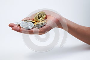 Asian young hand holding up many golden bitcoin and silver bitcoin in two hand. Close up of bitcoin in open hand isolated on white