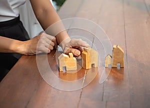Asian young hands  holding a wooden house model for design, Concept: mortgage financing for building a house for a family in the