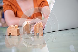 Asian young hands  holding a wooden house model for design, Concept: mortgage financing for building a house for a family in the