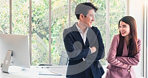 Asian young handsome business man talk with business woman so funny. Good relationship in working. Causing a good atmosphere at