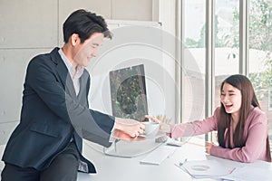 Asian young handsome businessman and beautiful business woman greetings by coffee