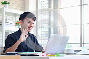 Asian young handsome businessman in black shirt meeting online in video conference, greeting and communicating on video call with