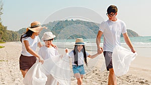 Asian young happy family activists collecting plastic waste and walking on beach. Asia volunteers help to keep nature clean up