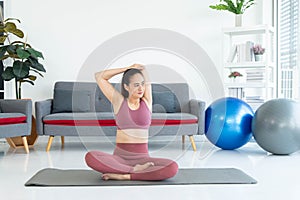 Asian young healthy woman in sportware practicing yoga at home, Sport girl meditating in living room at home