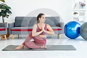 Asian young healthy woman in sportware practicing yoga at home, Sport girl meditating in living room at home