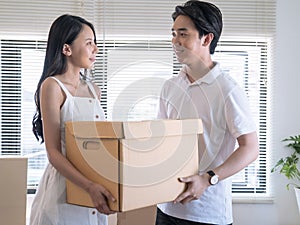 Asian young lovers help packing things in boxes