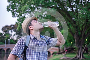 Asian young man age 25-30 year tourists backpacker. he was thirsty and was drinking water from a plastic bottle. during travel the