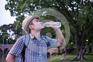 Asian young man age 25-30 year tourists backpacker. he was thirsty and was drinking water from a plastic bottle. during travel the