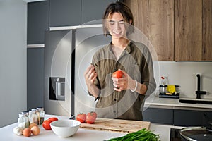 Asian young man cooking at kitchen.