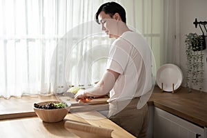 Asian young man cooking , preparing breakfast with healthy food in kitchen at home , healthy lifestyle