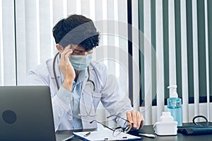 Asian young man doctor being exhausted and burnout in the office room