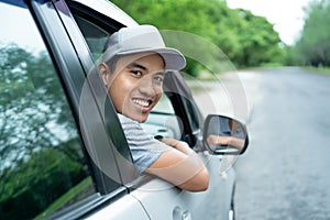 Asian young man driver look back from the open windows look at the camera