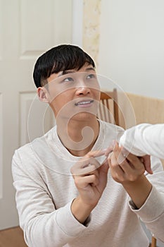 Asian young man kneeling and proposing to his girlfriend with ring