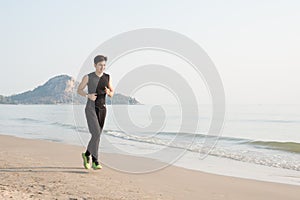 Asian young man running alone at the beach in Morning