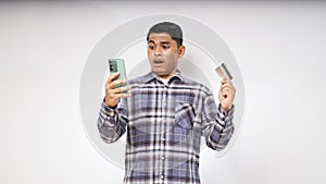 Asian young man with Shocked expression holding credit card and smartphone