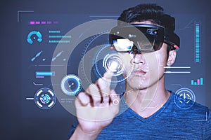 The Asian young man with virtual reality glasses. experiences VR hololens headset in studio with advanced technology