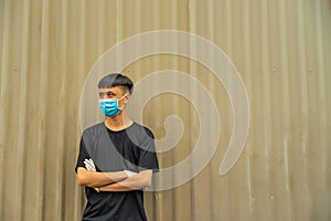 Asian young man wearing a protective hygiene mask over her face to protect flu and virus. Unwell influenza in infected man