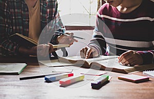 Asian young man and woman sitting pointing studying examining, Tutor books with friends Young students campus helps friend