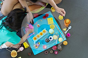 Asian young mom stay at home play with plasticine modeling clay with little daughter