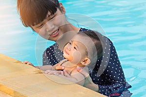 Asian young mother and cute eight month baby enjoying swimming p