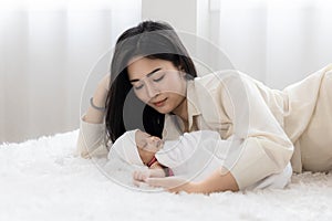 Asian young mother with cute newborn baby sleeping in bed. mother `s day concept