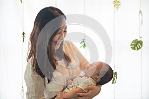 Asian young mother holding her baby in the bosom