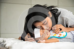 Asian young mother take care male baby gotten fever illness in bedroom