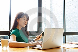 Asian young owner business woman working online, checking mail on laptop organizing working process in office. Copy space.