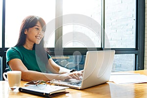 Asian young owner business woman working online, checking mail on laptop organizing working process in office. Copy space.