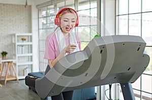 Asian young pretty cheerful happy healthy fitness girl in sexy sportswear with headphones listening to music playlist walking